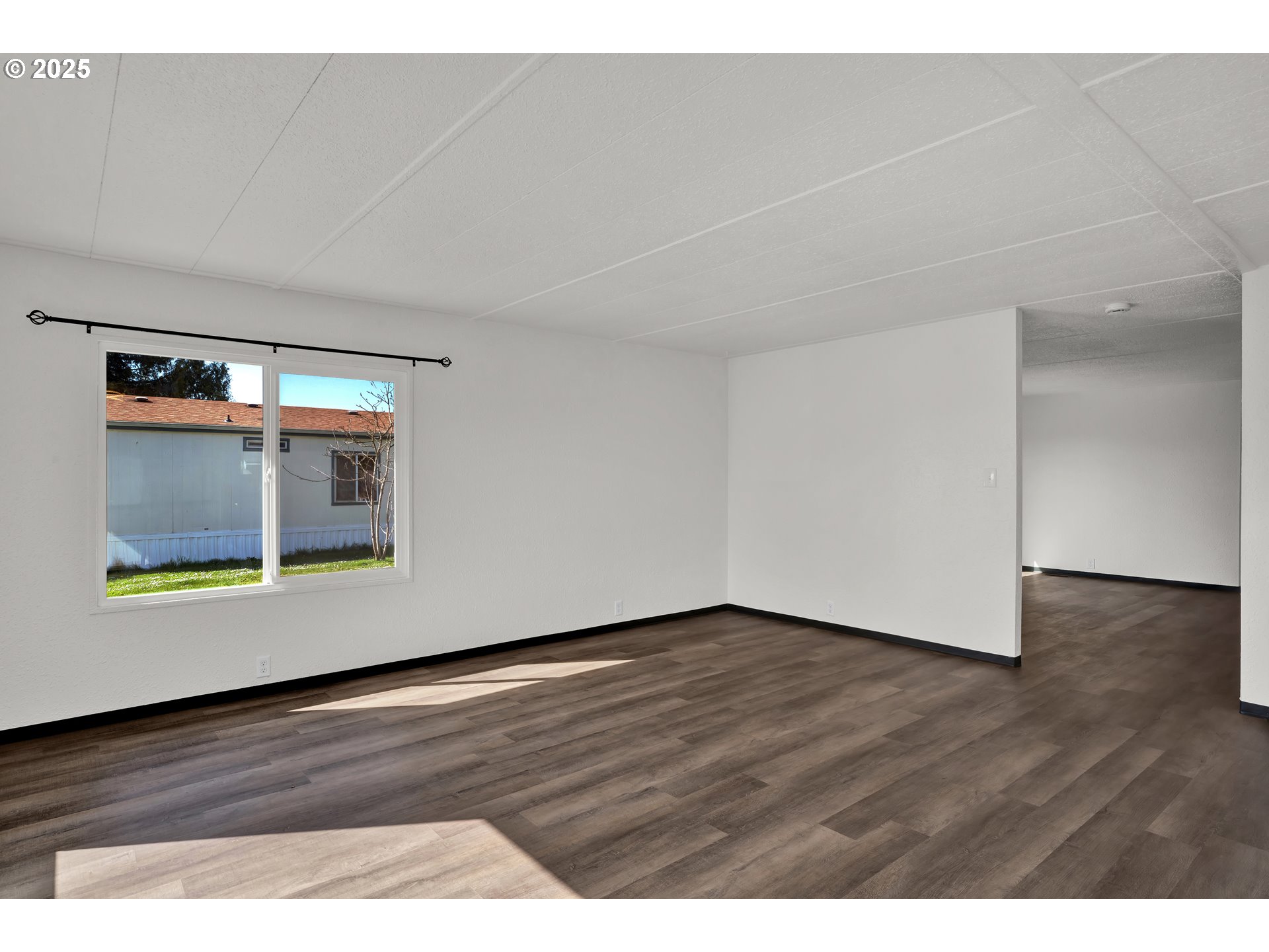 5055 Northeast Elliott Circle, Unit 8 Corvallis, OR 97330 - Photo 7 of 35 a view of an empty room with wooden floor and a window