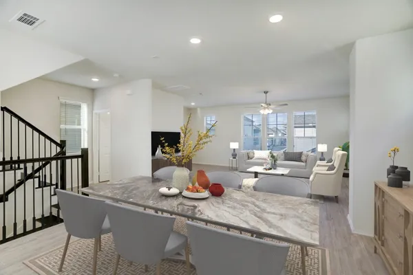 a room with lots of white furniture and wooden floor