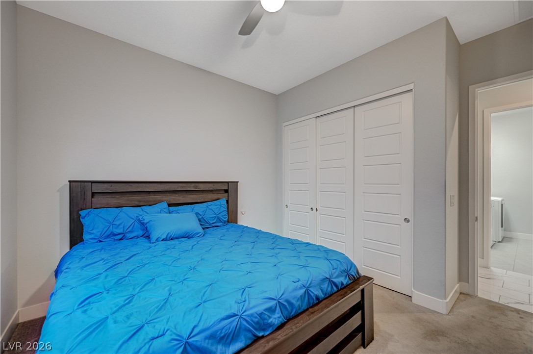3943 Reyes Avenue Las Vegas, NV 89141 - Photo 27 of 95 A comfortable bedroom features plush carpet and an adjacent laundry area for ultimate convenience.