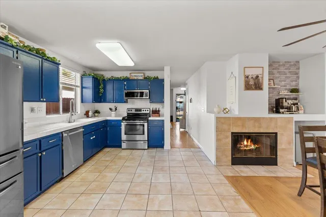 a large kitchen with stainless steel appliances granite countertop a stove granite counter tops and a view of living room