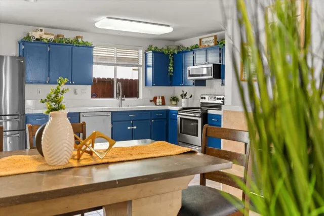 a kitchen with stainless steel appliances kitchen island granite countertop a refrigerator a stove a sink dishwasher and cabinets with wooden floor