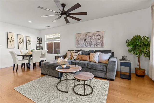 a living room with furniture a chandelier and a potted plant