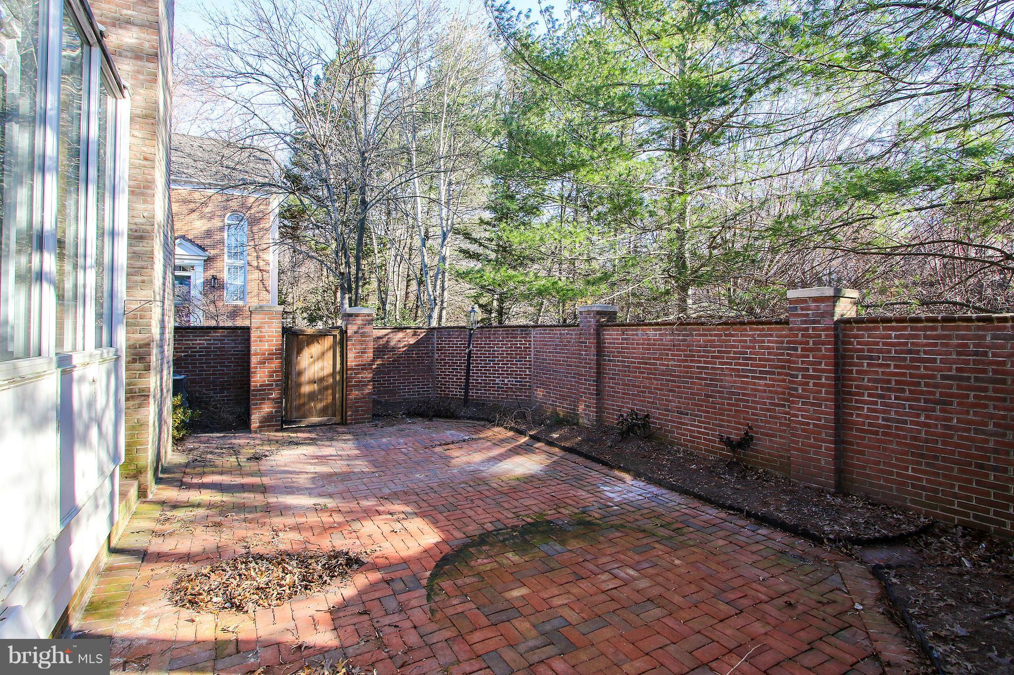 7900 Quarry Ridge Way Bethesda, MD 20817 - Photo 28 of 30 a view of a backyard with brick wall and a large tree