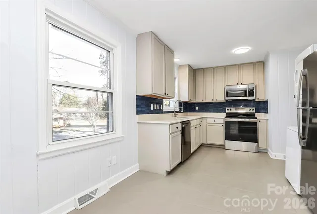 a kitchen with granite countertop white cabinets and stainless steel appliances