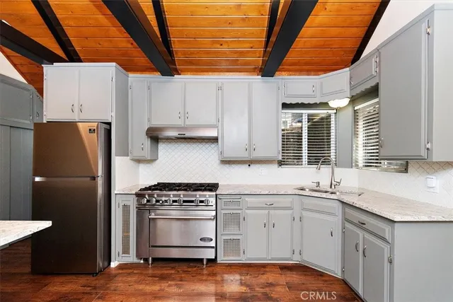 a kitchen with stainless steel appliances a stove a sink and a refrigerator
