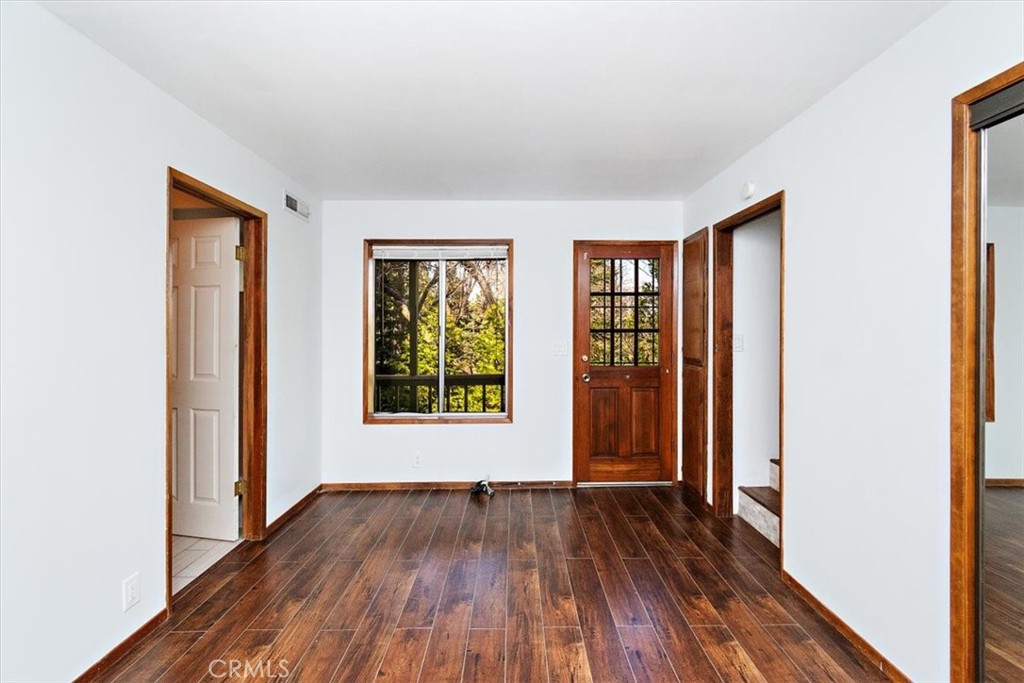 26432 Lake Forest Drive Twin Peaks, CA 92391 - Photo 21 of 27 an empty room with wooden floor and windows