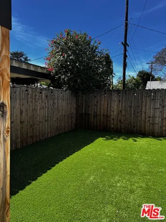 a view of backyard with wooden fence
