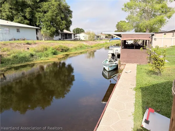 a view of a lake with a yard and potted plants