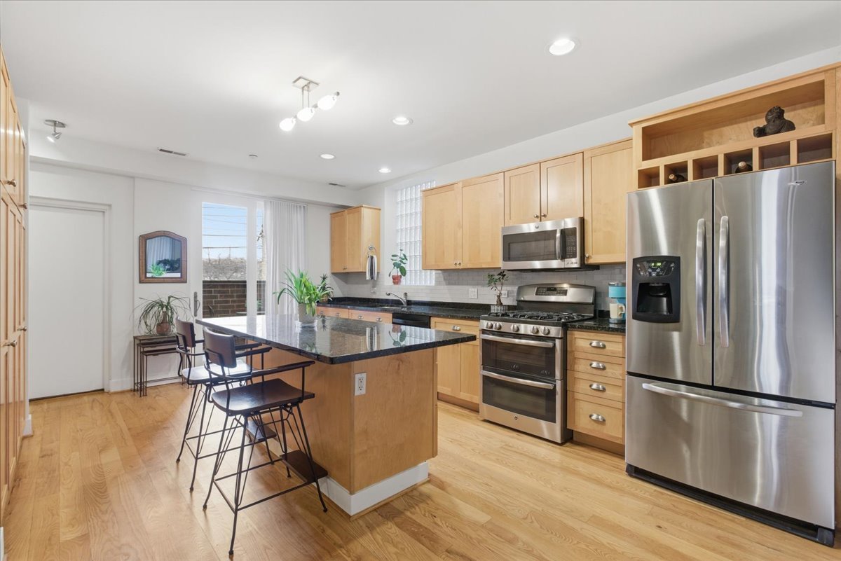 2515 Prairie Avenue, Unit 1E Evanston, IL 60201 - Photo 6 of 17 a kitchen with stainless steel appliances granite countertop a refrigerator a stove top oven a sink dishwasher and white cabinets with wooden floor