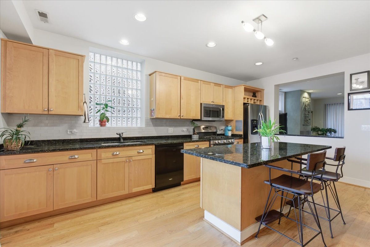 2515 Prairie Avenue, Unit 1E Evanston, IL 60201 - Photo 7 of 17 a kitchen with granite countertop a sink stove cabinets and refrigerator
