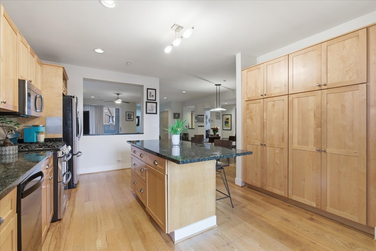 2515 Prairie Avenue, Unit 1E Evanston, IL 60201 - Photo 8 of 17 a kitchen with stainless steel appliances granite countertop a refrigerator a sink dishwasher a stove and white cabinets with wooden floor