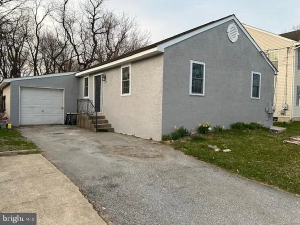 a backyard of a house with potted plants and large tree