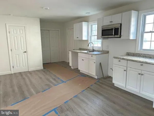a kitchen with a sink cabinets and wooden floor