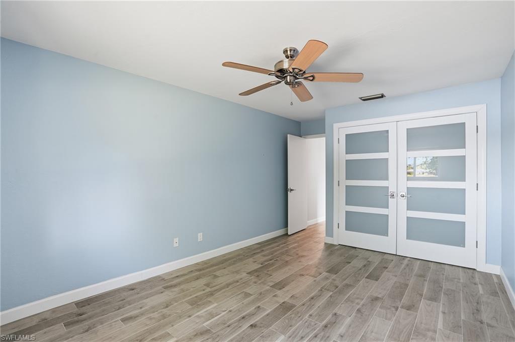 6735 Plantation Manor Loop Fort Myers, FL 33966 - Photo 35 of 46 a view of an empty room with a window and wooden floor