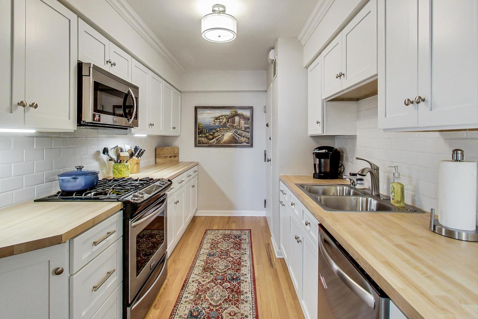 1350 North Astor Street, Unit 8B Chicago, IL 60610 - Photo 12 of 27 a kitchen with stainless steel appliances granite countertop a sink stove and refrigerator