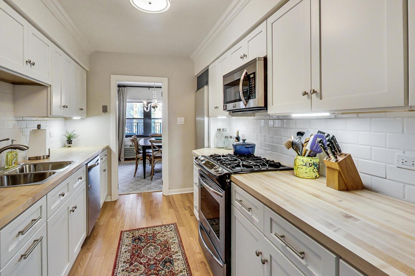 1350 North Astor Street, Unit 8B Chicago, IL 60610 - Photo 13 of 27 a kitchen with stainless steel appliances granite countertop a stove and a sink