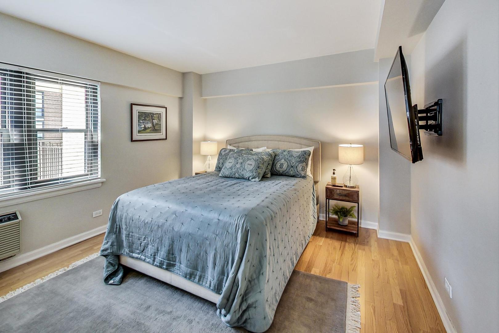 1350 North Astor Street, Unit 8B Chicago, IL 60610 - Photo 15 of 27 a bedroom with a bed and wooden floor