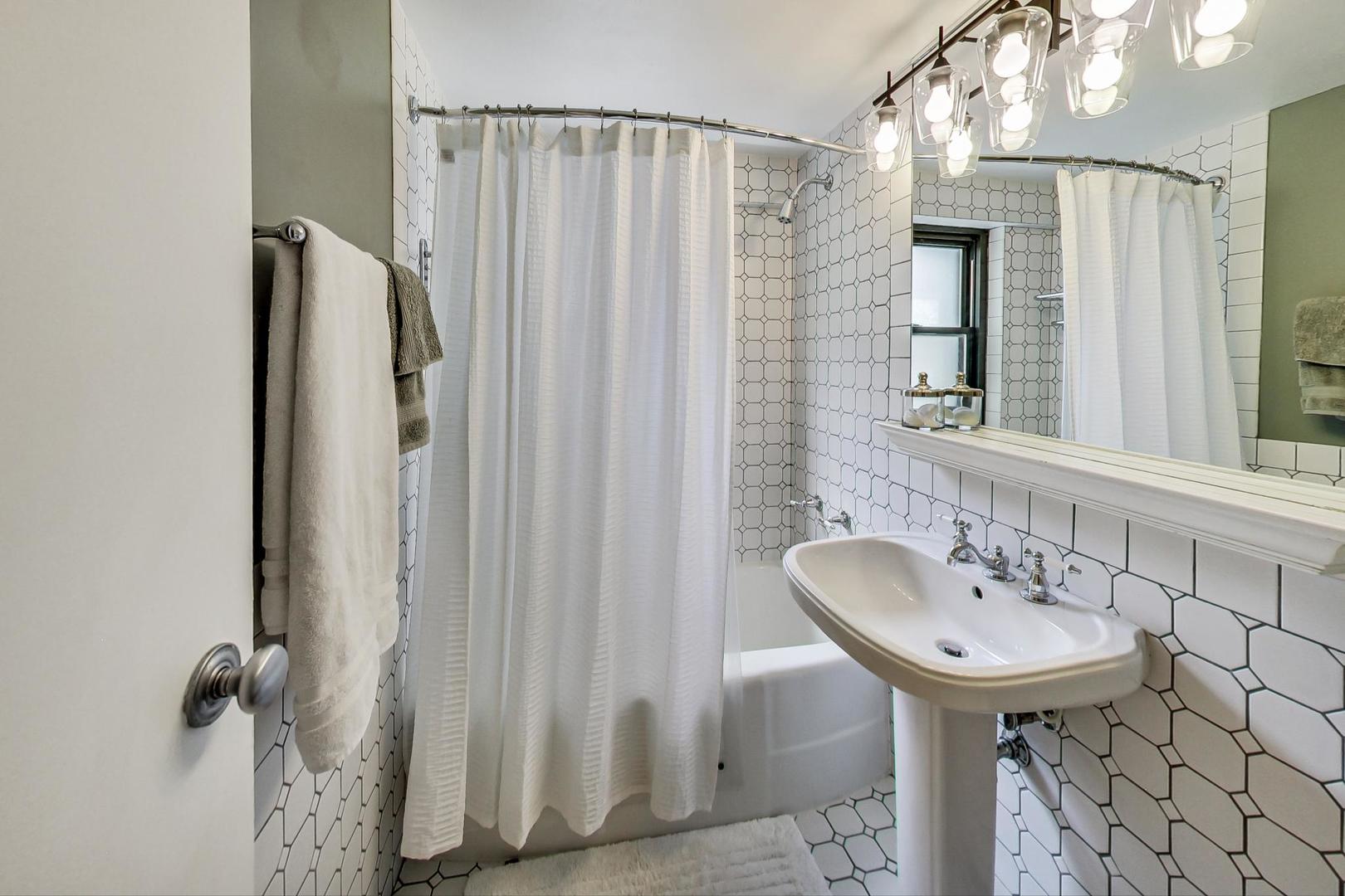 1350 North Astor Street, Unit 8B Chicago, IL 60610 - Photo 20 of 27 a bathroom with a sink a mirror and a shower