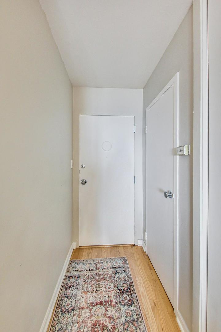 1350 North Astor Street, Unit 8B Chicago, IL 60610 - Photo 4 of 27 a view of hallway with window and wooden floor