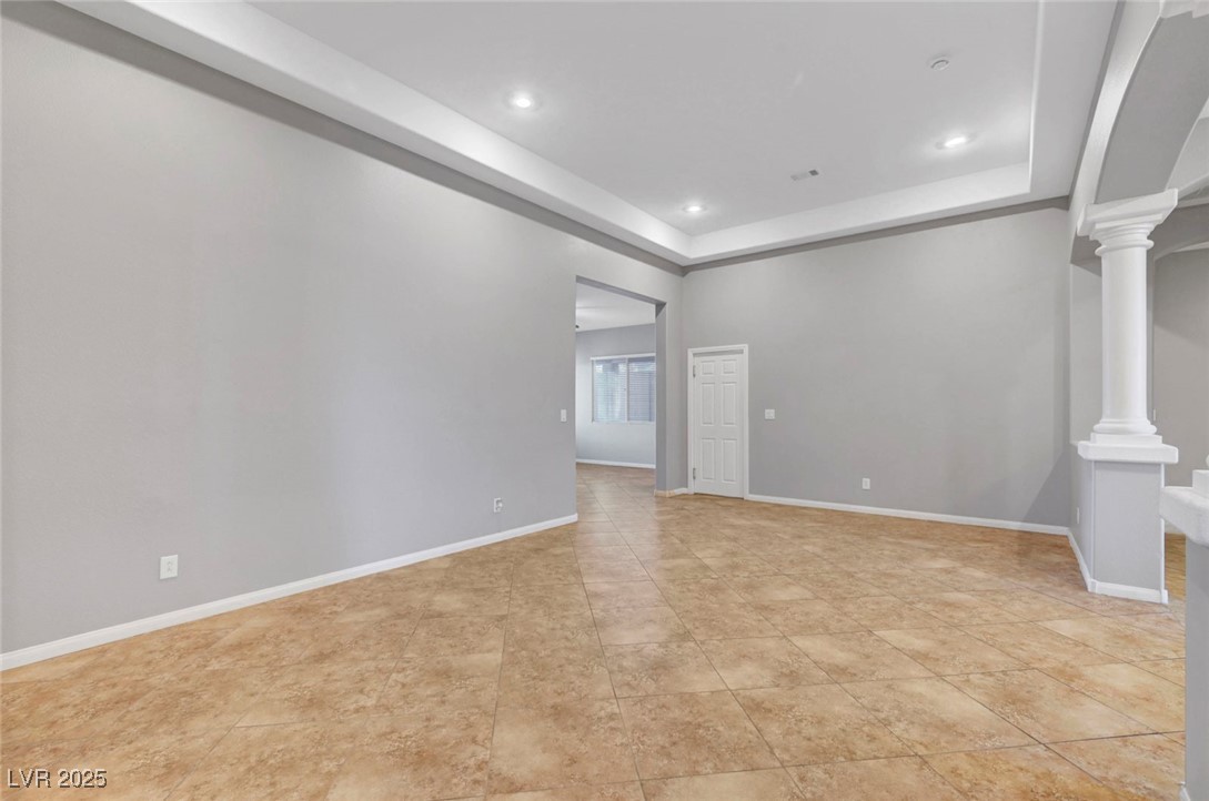 9417 Wisdom Valley Avenue Las Vegas, NV 89149 - Photo 11 of 67 Spare room featuring recessed lighting, a raised ceiling, and ornate columns