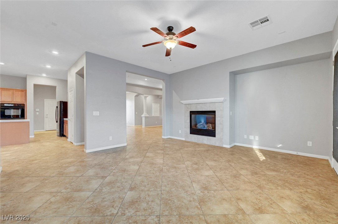 9417 Wisdom Valley Avenue Las Vegas, NV 89149 - Photo 14 of 67 Unfurnished living room with a ceiling fan, recessed lighting, a tile fireplace, and light tile patterned floors