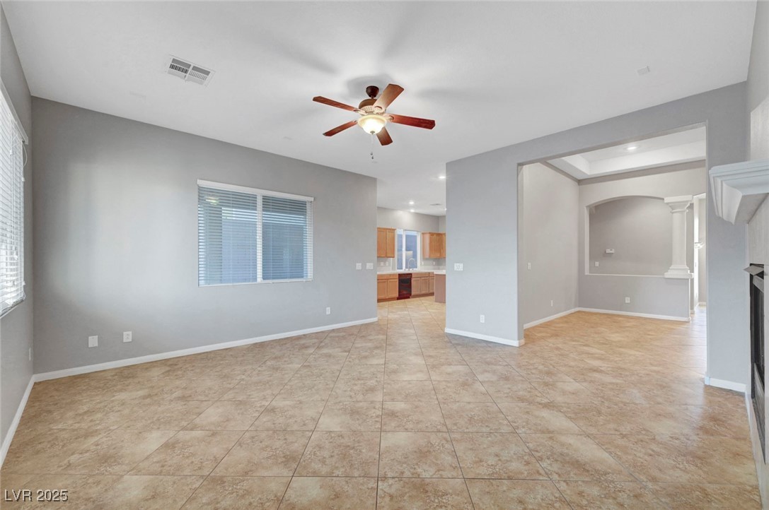 9417 Wisdom Valley Avenue Las Vegas, NV 89149 - Photo 15 of 67 Unfurnished living room with ceiling fan, arched walkways, and light tile patterned flooring
