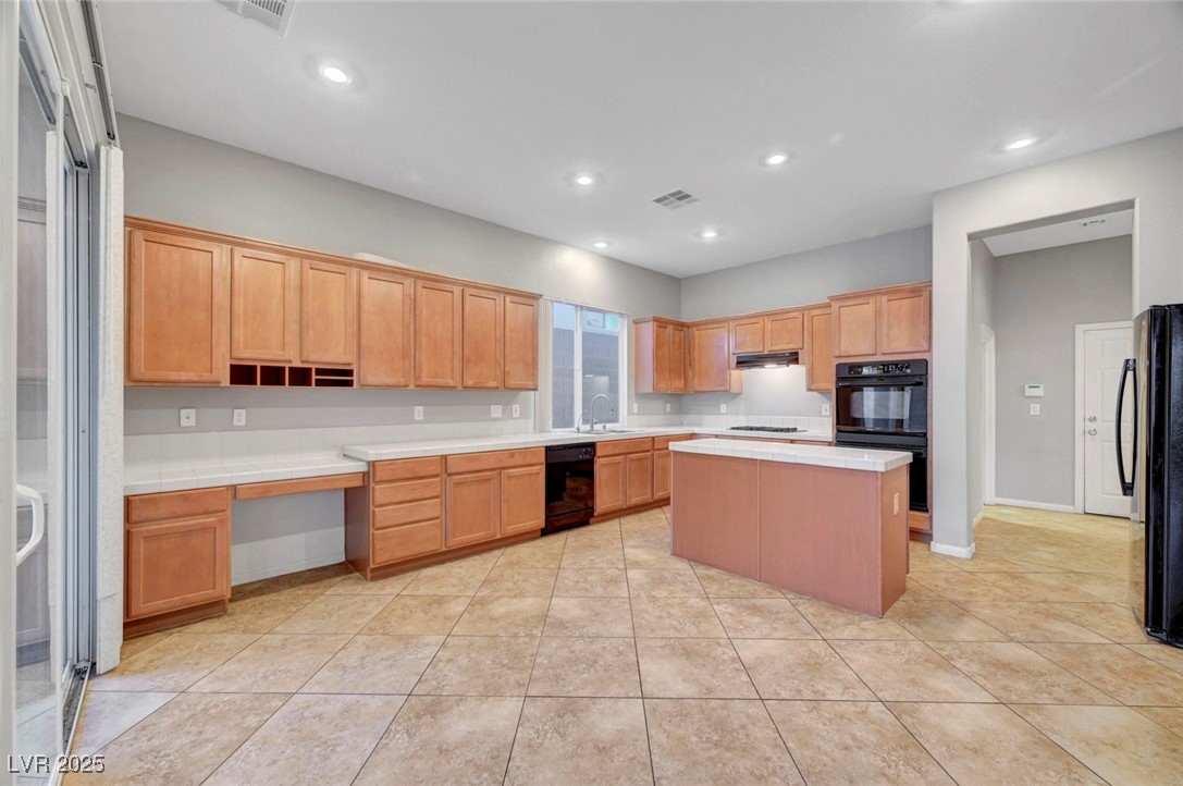 9417 Wisdom Valley Avenue Las Vegas, NV 89149 - Photo 16 of 67 Kitchen featuring a center island, black appliances, recessed lighting, light tile patterned floors, and light brown cabinetry