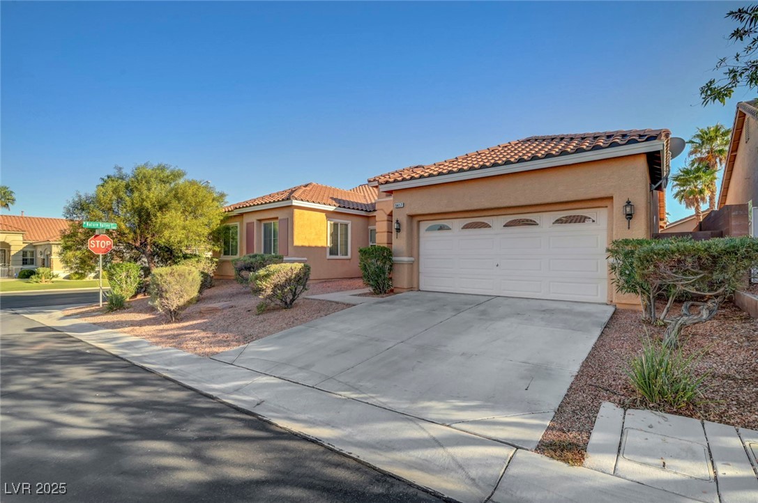 9417 Wisdom Valley Avenue Las Vegas, NV 89149 - Photo 2 of 67 Mediterranean / spanish home with stucco siding, driveway, a tile roof, and a garage