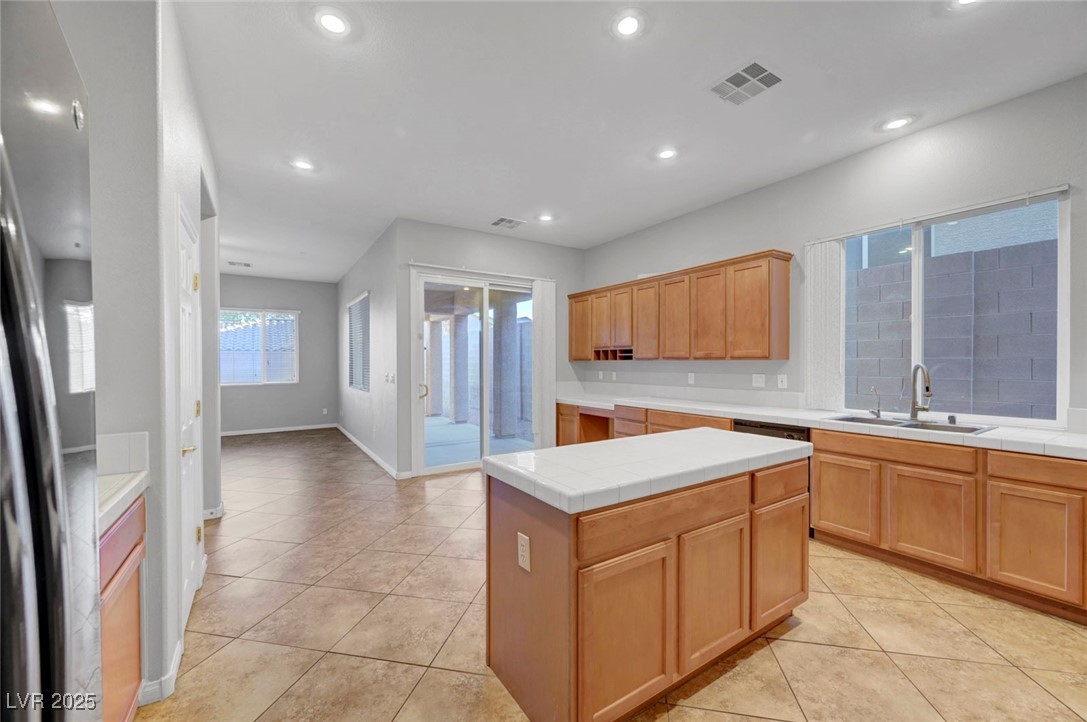 9417 Wisdom Valley Avenue Las Vegas, NV 89149 - Photo 21 of 67 Kitchen featuring tile counters, freestanding refrigerator, light tile patterned floors, recessed lighting, and a kitchen island