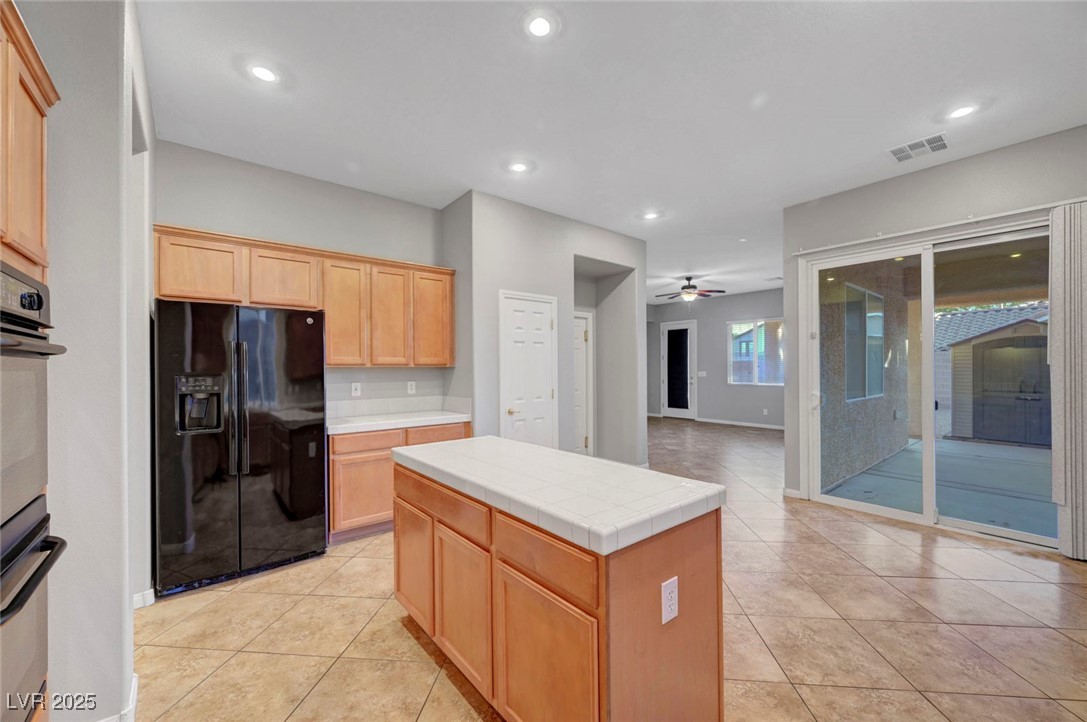9417 Wisdom Valley Avenue Las Vegas, NV 89149 - Photo 23 of 67 Kitchen with black fridge with ice dispenser, recessed lighting, light tile patterned flooring, a ceiling fan, and light brown cabinets