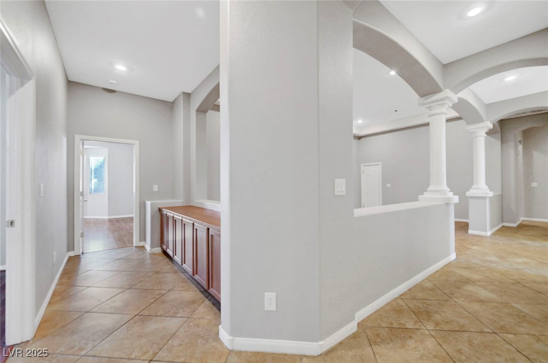 9417 Wisdom Valley Avenue Las Vegas, NV 89149 - Photo 28 of 67 Hallway featuring light tile patterned floors, arched walkways, and recessed lighting