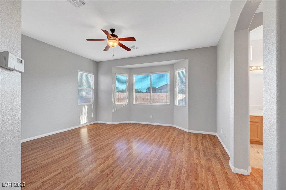 9417 Wisdom Valley Avenue Las Vegas, NV 89149 - Photo 30 of 67 Empty room featuring light wood-style floors, a ceiling fan, and a textured wall