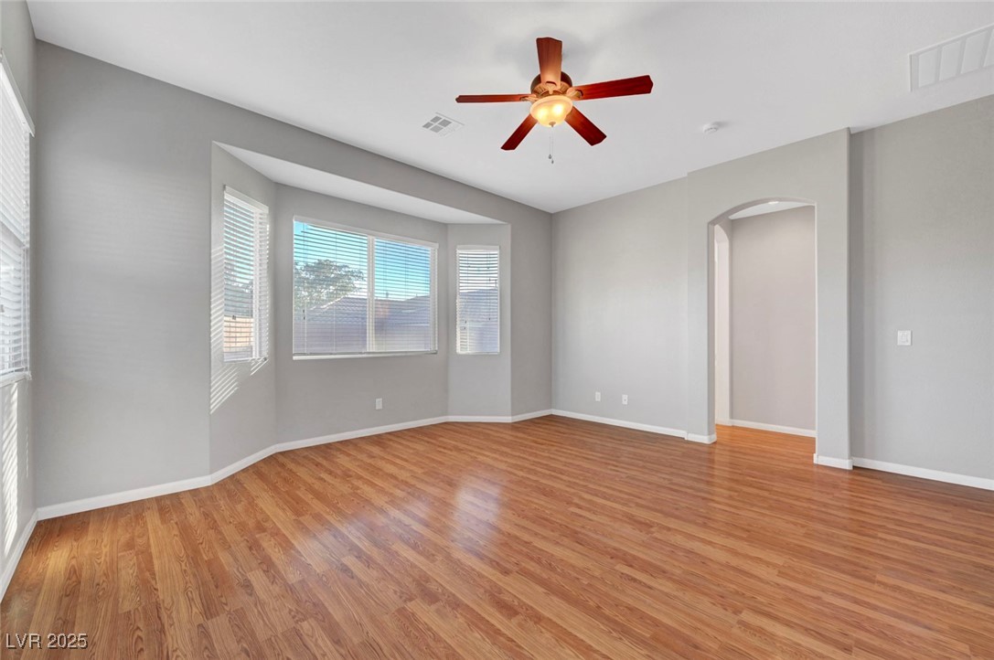 9417 Wisdom Valley Avenue Las Vegas, NV 89149 - Photo 33 of 67 Spare room with light wood finished floors, arched walkways, and ceiling fan
