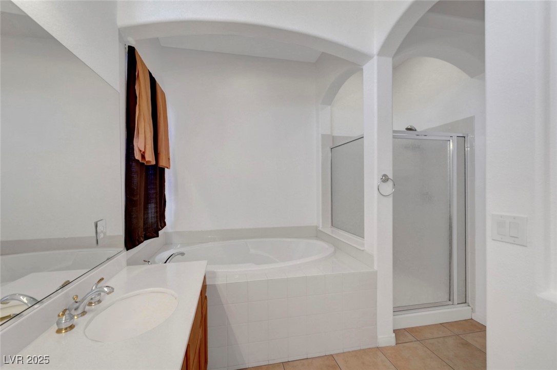 9417 Wisdom Valley Avenue Las Vegas, NV 89149 - Photo 36 of 67 Bathroom with vanity, light tile patterned floors, a stall shower, and a bath