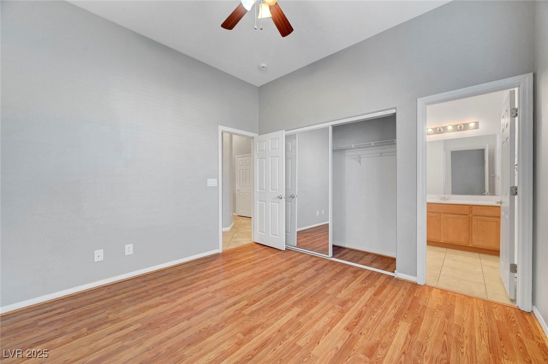 9417 Wisdom Valley Avenue Las Vegas, NV 89149 - Photo 43 of 67 Unfurnished bedroom featuring light wood-style flooring, a closet, a ceiling fan, and ensuite bathroom