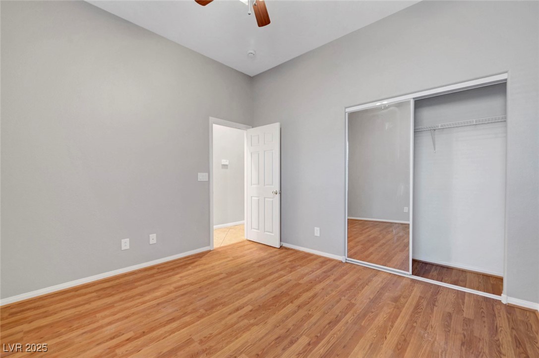 9417 Wisdom Valley Avenue Las Vegas, NV 89149 - Photo 47 of 67 Unfurnished bedroom with light wood-style flooring, a ceiling fan, and a closet