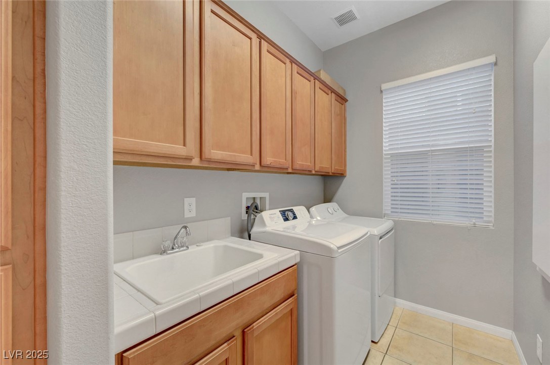 9417 Wisdom Valley Avenue Las Vegas, NV 89149 - Photo 55 of 67 Laundry area featuring cabinet space, light tile patterned floors, and washer and clothes dryer