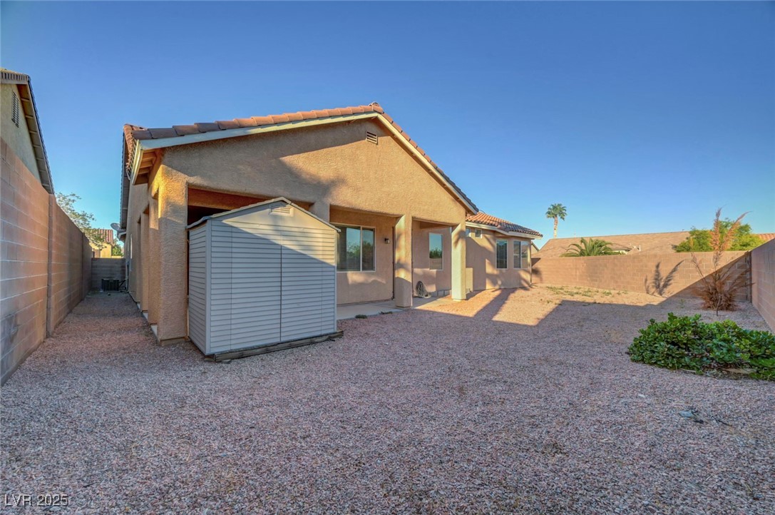 9417 Wisdom Valley Avenue Las Vegas, NV 89149 - Photo 64 of 67 Back of property with a fenced backyard, stucco siding, a shed, a patio area, and a tile roof