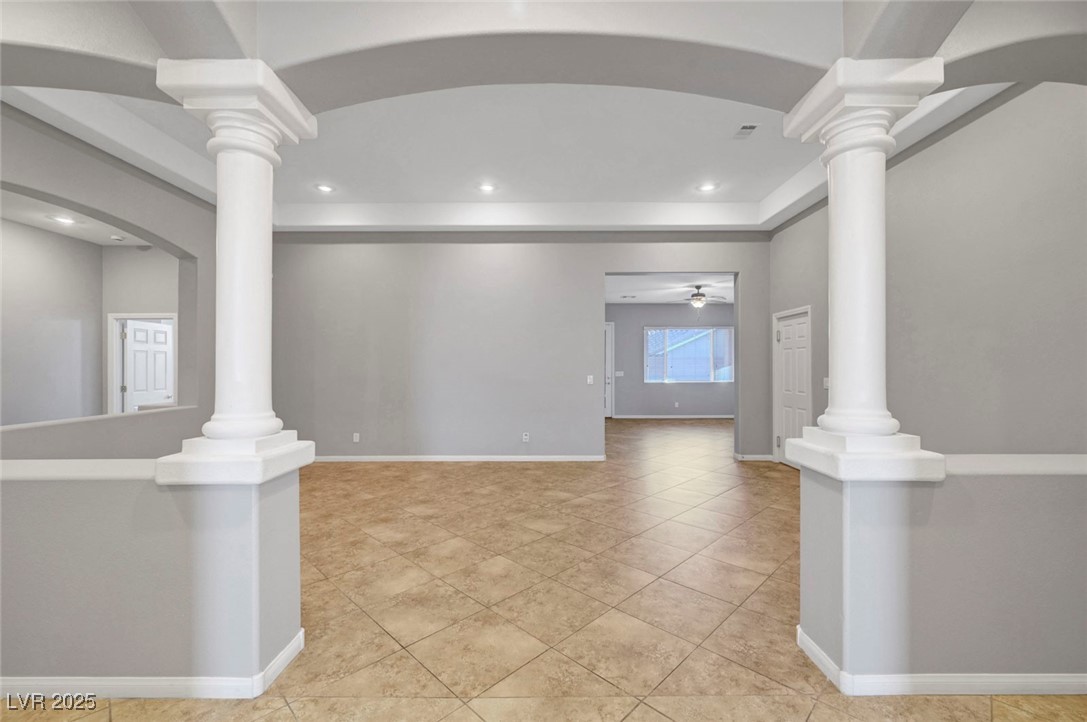 9417 Wisdom Valley Avenue Las Vegas, NV 89149 - Photo 7 of 67 Unfurnished room featuring arched walkways, light tile patterned floors, ornate columns, and recessed lighting