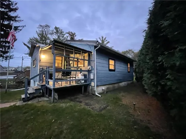a view of a chair and table in backyard of the house