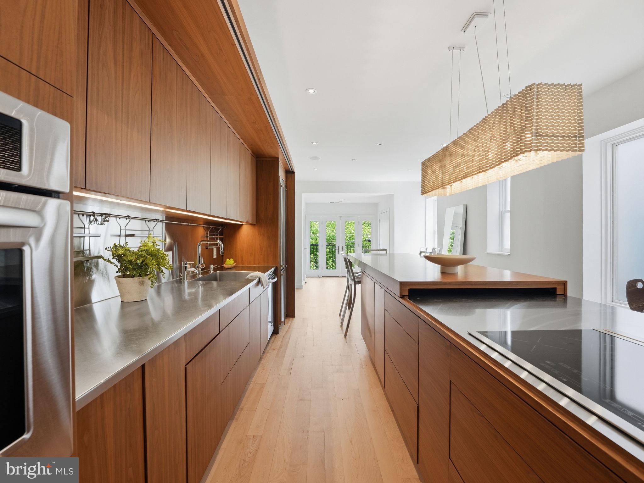 1845 Calvert Street Northwest Washington, DC 20009 - Photo 14 of 48 a kitchen with stainless steel appliances a sink a stove and a wooden cabinets