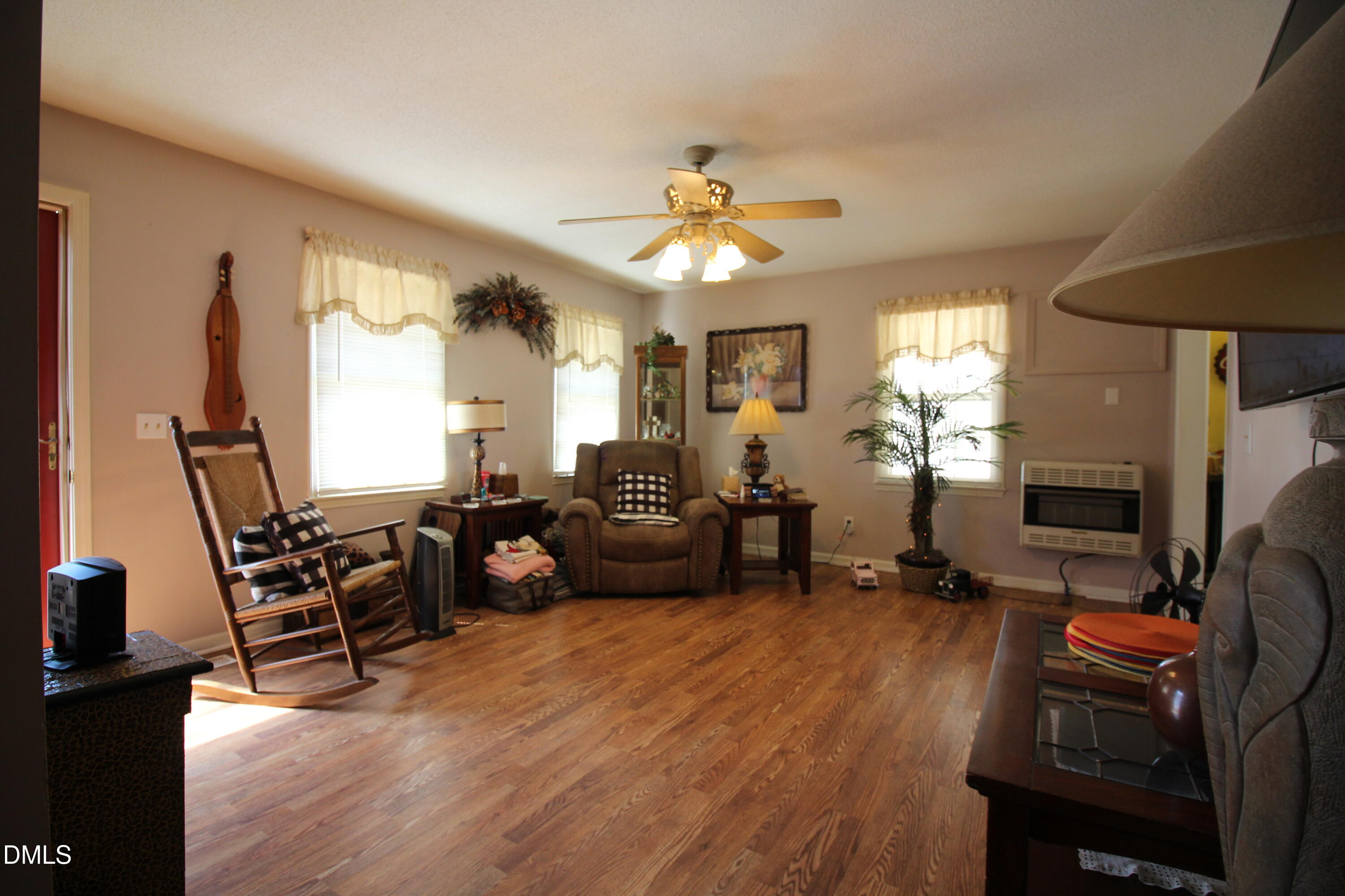 56 Ash Street Coats, NC 27521 - Photo 18 of 28 a living room with furniture a fireplace and a flat screen tv
