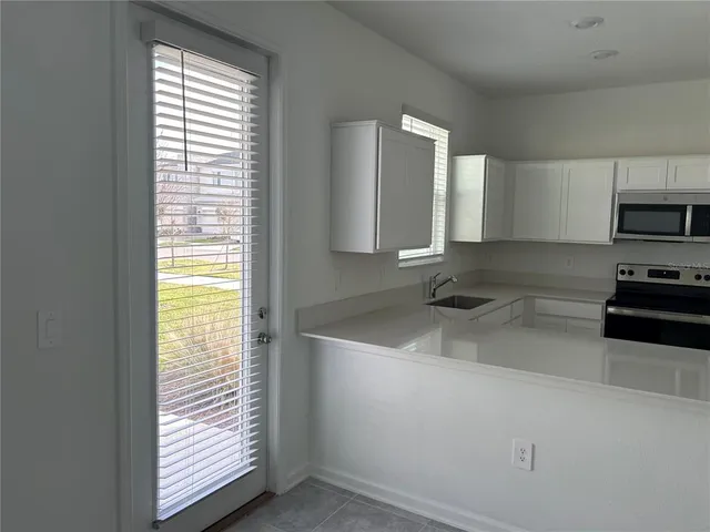 a kitchen with stainless steel appliances granite countertop a sink and a stove