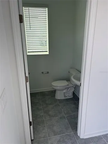 a bathroom with a toilet a sink and a window
