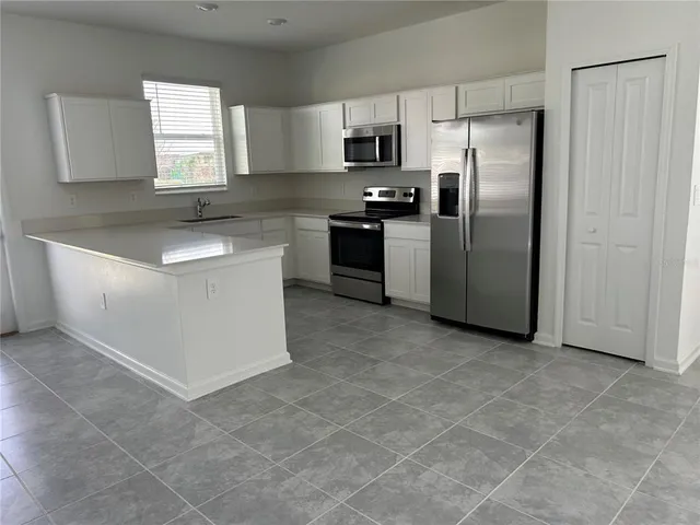 a kitchen with stainless steel appliances a refrigerator sink and microwave