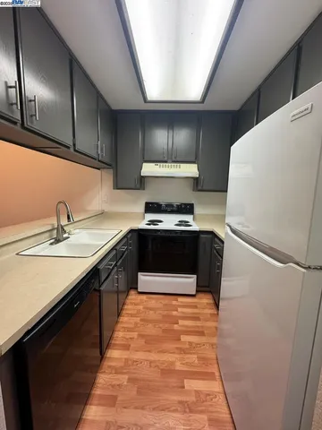 a kitchen with sink a stove and refrigerator