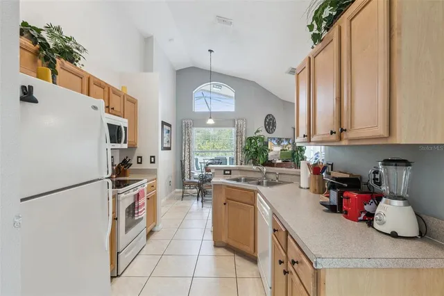 a kitchen with stainless steel appliances granite countertop a sink a stove and a refrigerator