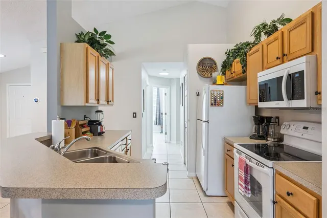 a kitchen with stainless steel appliances granite countertop a sink a stove and a refrigerator
