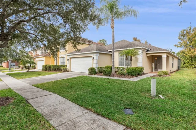 a front view of a house with a garden and tree