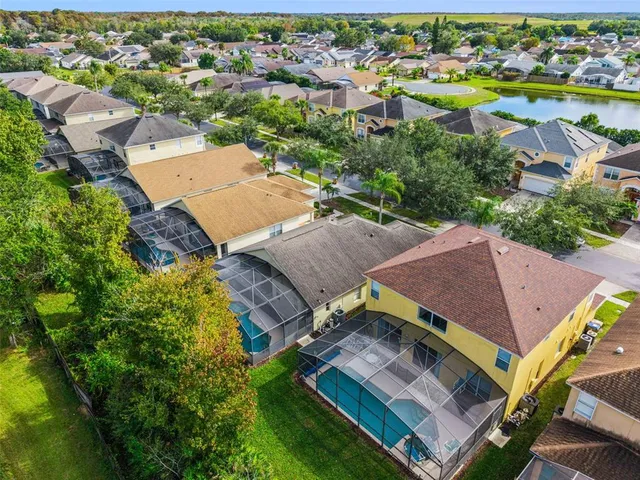 an aerial view of residential houses with outdoor space and trees all around